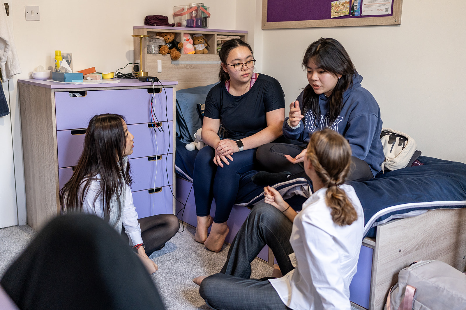 Four girls in a boarding room chatting